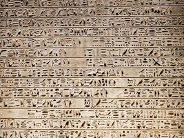 Old Egyptian hieroglyphs on an stone background. Ancient Egyptian hieroglyphs as pattern in Tombs. photo