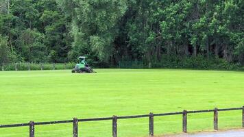 A tractor is on the grass in a field video