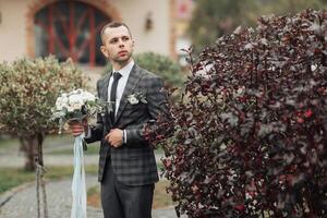 A man in a suit holding a bouquet of flowers photo