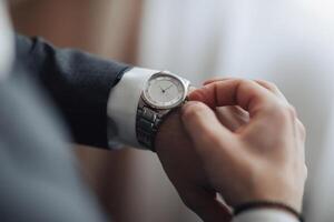A man is wearing a watch and looking at it photo