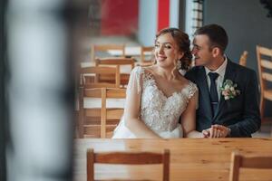 A bride and groom are sitting at a table in a restaurant photo