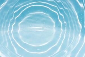 Blue water with ripples on the surface. Defocus blurred transparent blue colored clear calm water surface texture with splashes and bubbles. Water waves with shining pattern texture background. photo