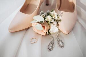 A pair of high heels with a flower on top and a ring on the left foot photo