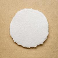circular sheet of blank white watercolor paper against handmade amate bark paper photo