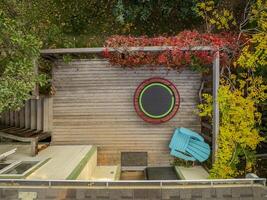 mini trampoline for fitness exercising and rebounding in a backyard patio, top aerial view in fall scenery photo