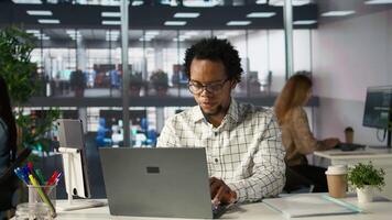 Skilled businessman at his office desk working on report writing, data analysis and deadline management. Male executive looking to expand the enterprise globally, multitasking at job. Camera B. video