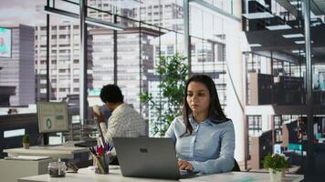 Indian businesswoman reviewing business forecasts and plans on her laptop at office desk, strategy planning. Data analyst focuses on company objectives and resource allocation. Camera B. video