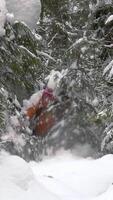 A man with a backpack travels in the forest in winter. The concept of travel and active lifestyle. vertical footage video