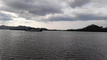 West Lombok Regency, Indonesia - November 4, 2024. A ferry boat is entering the harbor in the afternoon with cloudy weather. The harbor is called Lembar Harbor in West Lombok Regency, Lombok Island. video
