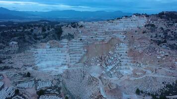 Aerial view of Open-air mining activity in a white marble mine. video