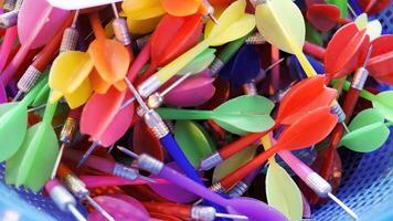 Top view of Colorful used darts in plastic basket contain ready for player in Carnival festival game pop balloons on the wall to win a prize at Thai Red Cross Fair night market fun fair photo