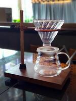 Set of pourover coffee server including heat resistant glass dripper mug, reusable filters or clever dripper, and wooden stand bracket holder, hand drip machine photo