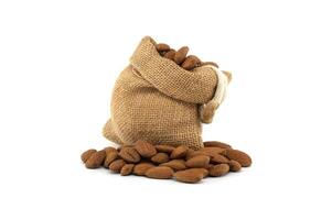 Rustic burlap sack overflowing with fresh almonds isolated on white background photo