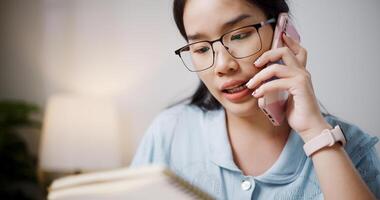 Selective focus, Female freelancer sitting at desk explain work to co-workers via mobile phone in home office. photo