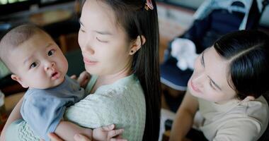 High angle view, Two happy women having fun playing with a little boy in a coffee shop. Family enjoying time together. Happy lifestyle. photo