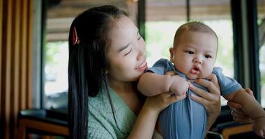 Selective focus, Happy moment in a coffee shop as two women smile and play with a baby boy. Family enjoying time together. photo