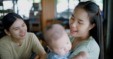 Selective focus, Two happy women having fun playing with a little boy in a coffee shop. Family enjoying time together. Happy lifestyle. photo