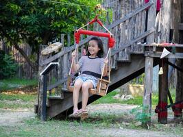 Kids play outdoors on a playground with modern slides, rope net bridges, climbing swings, climbers in summer. photo