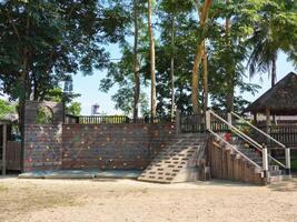 Summer park playground with swings, slides and climbing equipment. Modern wooden playground equipment for children's amusement park. photo