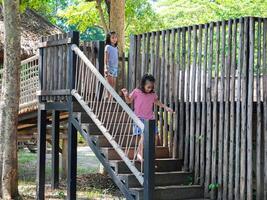 Kids play outdoors on a playground with modern slides, rope net bridges, climbing swings, climbers in summer. photo