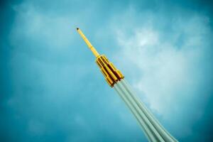 A tall tower with a yellow pole sticking out of it photo