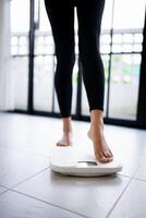 Lose weight. Fat diet and scale feet standing on electronic scales for weight control. Measurement instrument in kilogram for diet photo