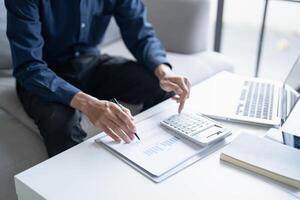 Man calculate finances home pay bills taxes on mobile phone and calculator financial at home photo