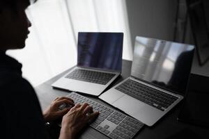 Asian man software engineer Working on Computer at office desk for writing program code IT Software Engineer finding errors tech support devops creating digital photo