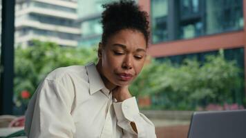 cansado fatigado africano americano mujer conmovedor cuello sufrimiento salud hembra niña mujer de negocios ciudad dolor de espalda dolor trabajando ordenador portátil empleador sensación incomodidad indispuesto enfermo insalubre negocio fuera de espina video