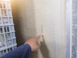 An engineer is checking the thickness of the feather dust on the hatching machine using his index finger. photo