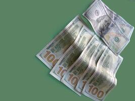 A stack of green 100 bills. Concept of wealth and prosperity. The green color of the bills and the green background create a harmonious and calming atmosphere. photo