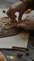 Vertical . Making Christmas cookies. Hands cutting shapes with cookie cutters from rolled dough. video