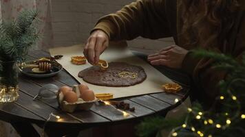 Preparing Christmas gingerbread cookies. Hands cutting ginger cookies with biscuit cutters on table. video