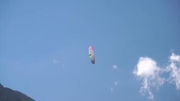 Paragliding Sky Clouds - A paraglider soars through the clear blue sky on a sunny day, with fluffy white clouds in the background. video