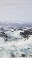 large snow patch left over on the volcanic rock field of a mountain in summer video