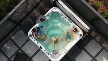 The family swims in a bubble pool in their courtyard. View from above video