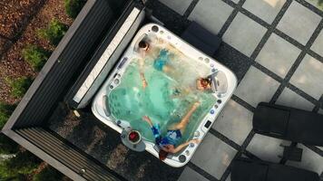 The family swims in a bubble pool in their courtyard. View from above video