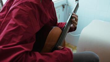 Man Gently Pulling The Strings Of His Guitar video