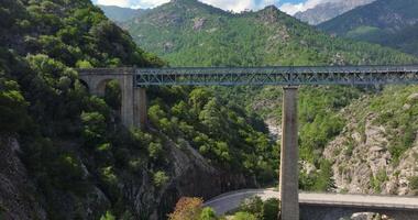 Drone flyby of a railway bridge in Corsicas dramatic mountains highlighting rugged landscape views video