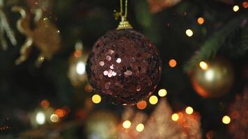 Merry Christmas Xmas happy holidays. Golden ornament decoration ball and defocused garland lights on classic decorated Christmas tree. Christmas tree with brown ornaments. Christmas eve at home video