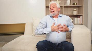 Pain on heart, heart attack. Unhappy middle aged senior man suffering from chest pain heart attack problems with health at home. Mature old senior grandfather touching chest experiencing infarction video