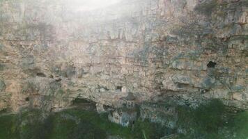 Aerial descending view Horomayr Monastery monastic complex in the Lori Province of Armenia, Odzun village. Monastery nestled amongst rock and cliff escarpments with caves for protection video