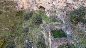 Aerial panning left view Horomayr Monastery monastic complex in the Lori Province of Armenia, Odzun village. Monastery nestled amongst rock and cliff escarpments with caves for protection video