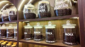 Roasted coffee beans in glass jars on shelves in coffee shops. Various specialty coffees, each with unique production methods, distinct flavors, and diverse origins. cafe in Hanoi, Vietnam. 4k footage video