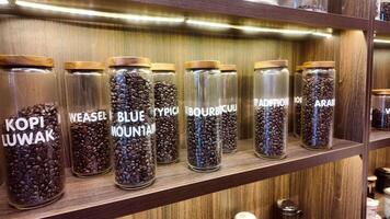 Roasted coffee beans in glass jars on shelves in coffee shops. Various specialty coffees, each with unique production methods, distinct flavors, and diverse origins. cafe in Hanoi, Vietnam. 4k footage video