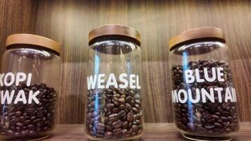 Roasted coffee beans in glass jars on shelves in coffee shops. Various specialty coffees, each with unique production methods, distinct flavors, and diverse origins. cafe in Hanoi, Vietnam. 4k footage video