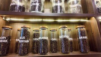Roasted coffee beans in glass jars on shelves in coffee shops. Various specialty coffees, each with unique production methods, distinct flavors, and diverse origins. cafe in Hanoi, Vietnam. 4k footage video
