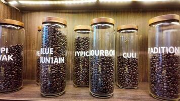 Roasted coffee beans in glass jars on shelves in coffee shops. Various specialty coffees, each with unique production methods, distinct flavors, and diverse origins. cafe in Hanoi, Vietnam. 4k footage video