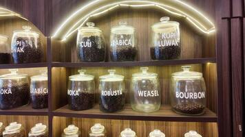 Roasted coffee beans in glass jars on shelves in coffee shops. Various specialty coffees, each with unique production methods, distinct flavors, and diverse origins. cafe in Hanoi, Vietnam. 4k footage video