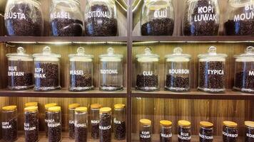 Roasted coffee beans in glass jars on shelves in coffee shops. Various specialty coffees, each with unique production methods, distinct flavors, and diverse origins. cafe in Hanoi, Vietnam. 4k footage video